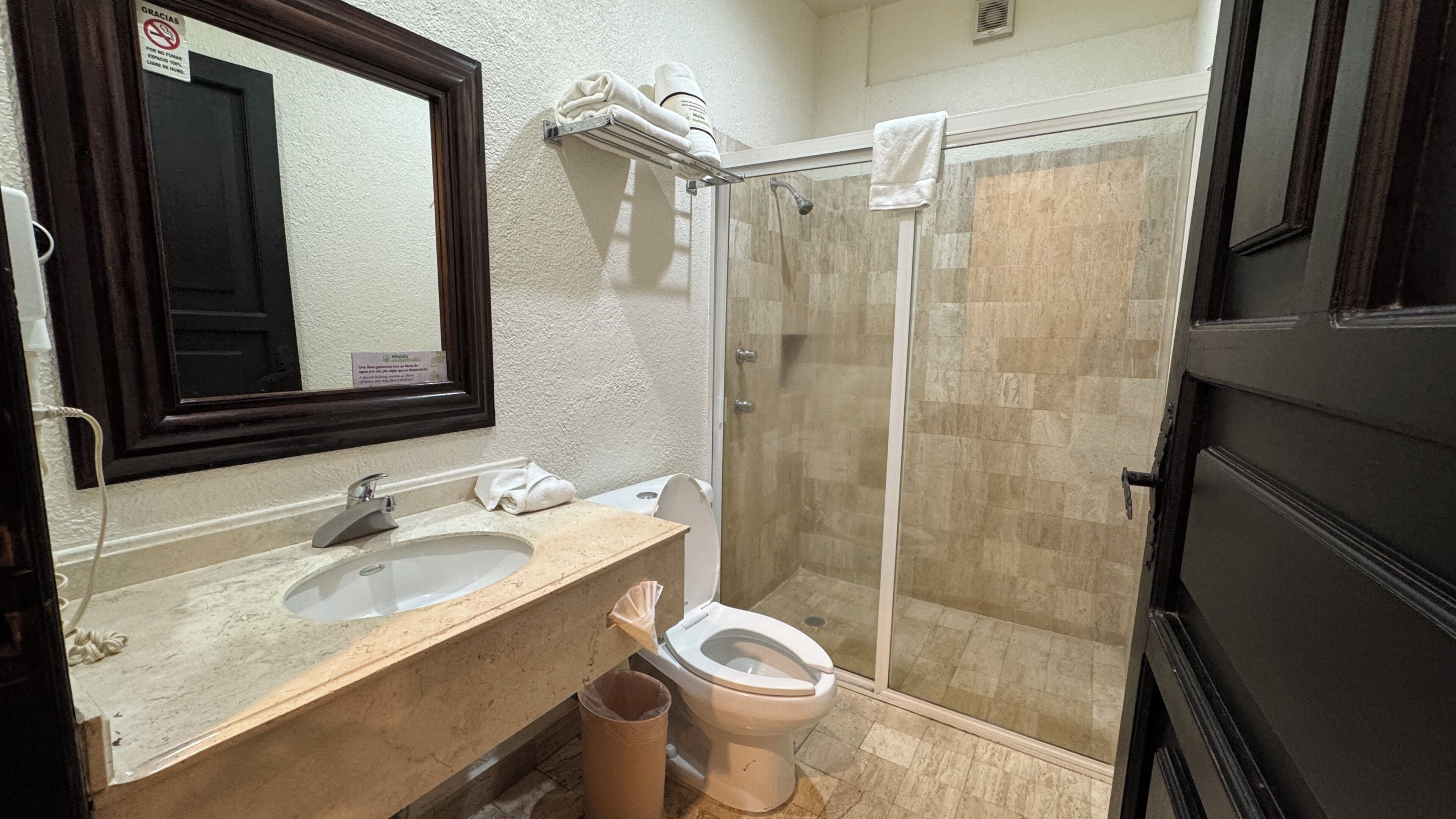 Une salle de bain équipée d’un lavabo, d’un miroir, de toilettes et d’une douche.
