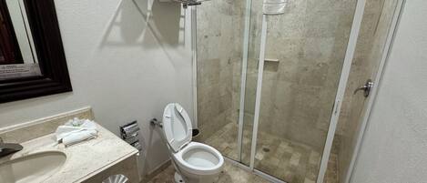 A bathroom with a toilet, sink, and shower.