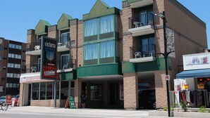 A multi-story building with a green roof, large windows, and balconies. - Victoria Motor Inn (Niagara Falls)
