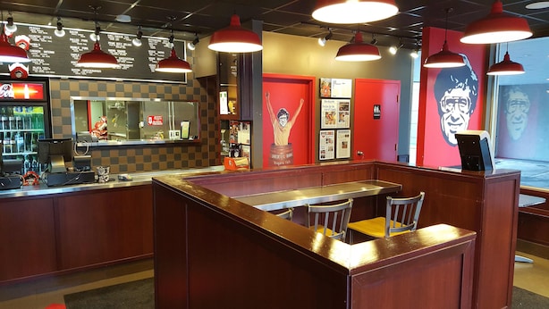 A restaurant with a counter, booths, and a menu board. - Victoria Motor Inn (Niagara Falls)