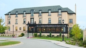 A multi-story hotel with a beige facade, a black entrance, and a sign indicating it is a "Hotel". - St. Brendan's Inn (Green Bay)