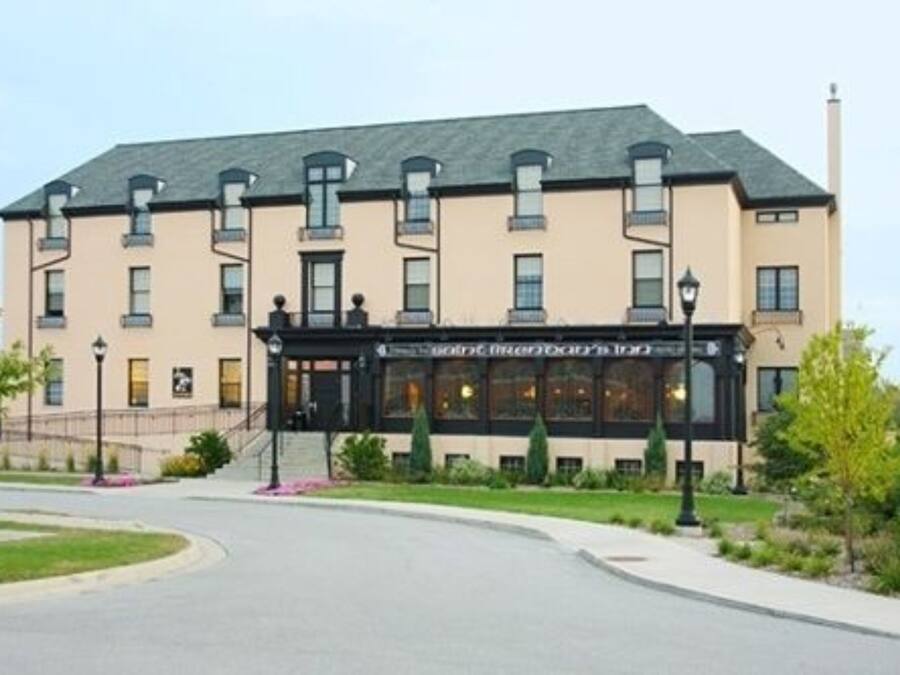 A multi-story hotel with a beige facade, a black entrance, and a sign indicating it is a "Hotel".
