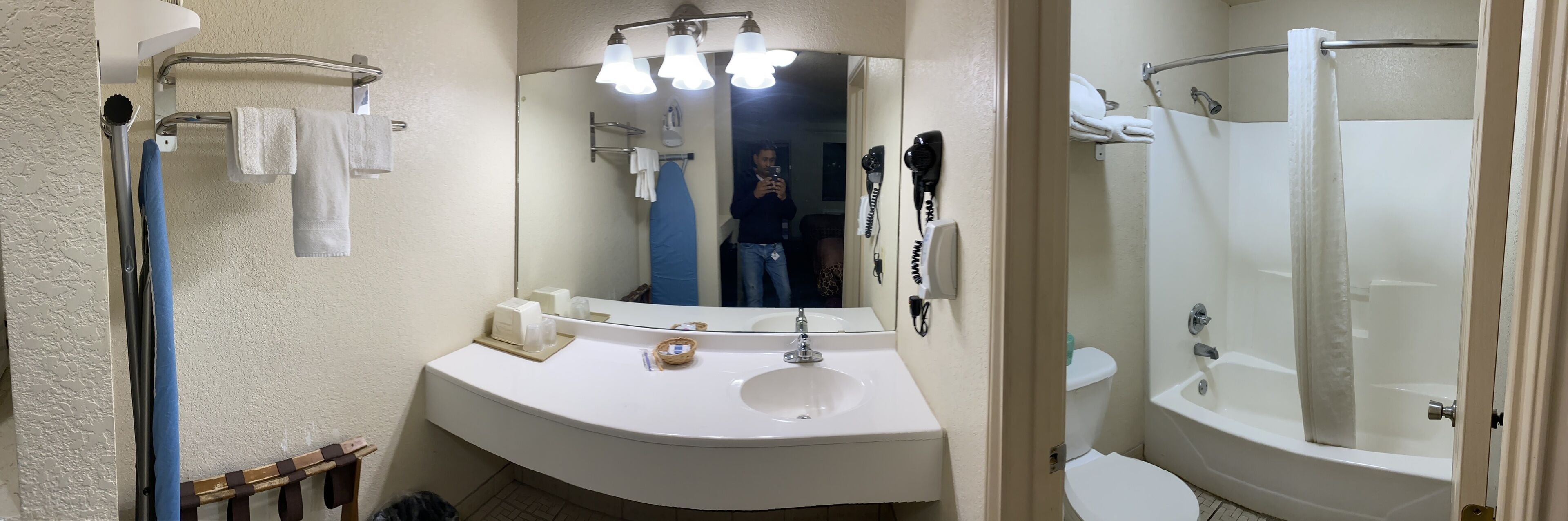 A bathroom with a white sink, mirror, and a shower area.