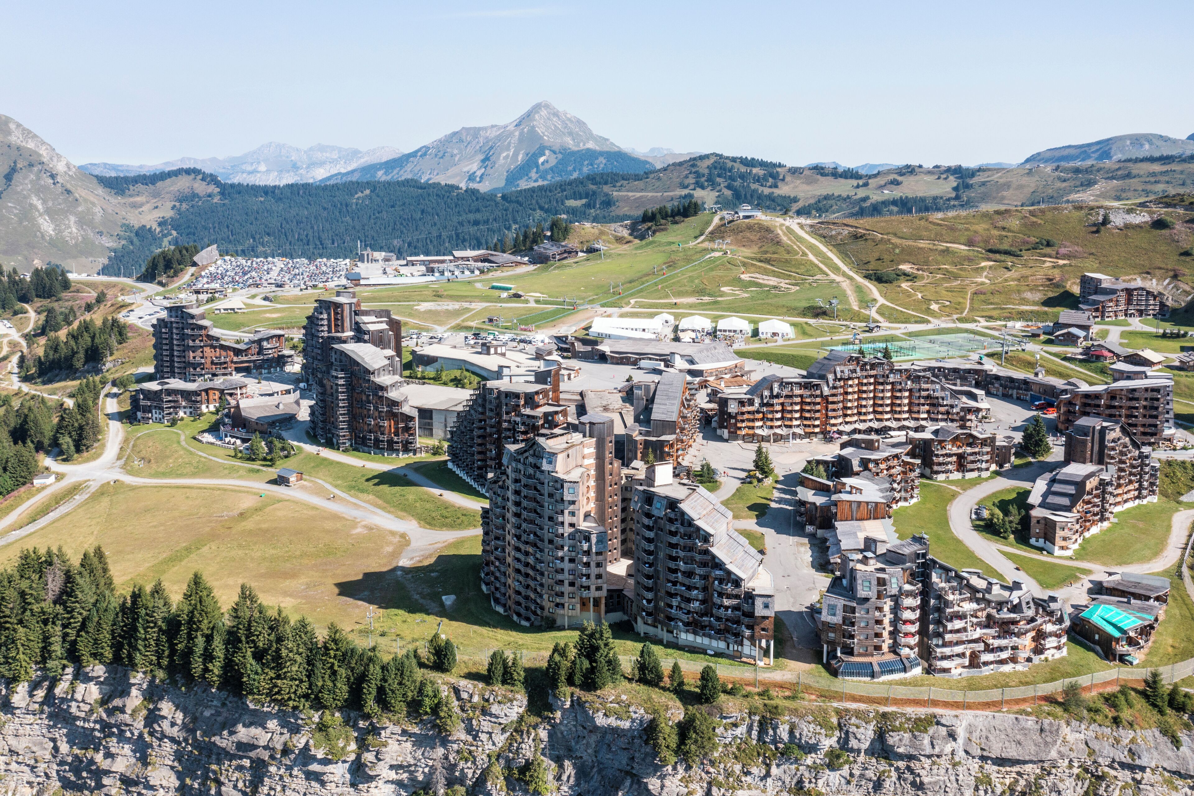 Een bergachtig resortgebied met moderne gebouwen, wegen en een piste.