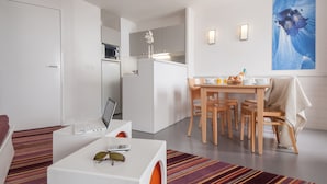 A modern hotel room with a dining area, a kitchen, and a large window with a view. - Résidence Pierre & Vacances Antarès (Avoriaz)