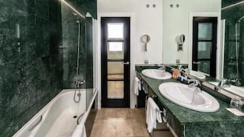 Un baño moderno con bañera, dos lavamanos y ducha.