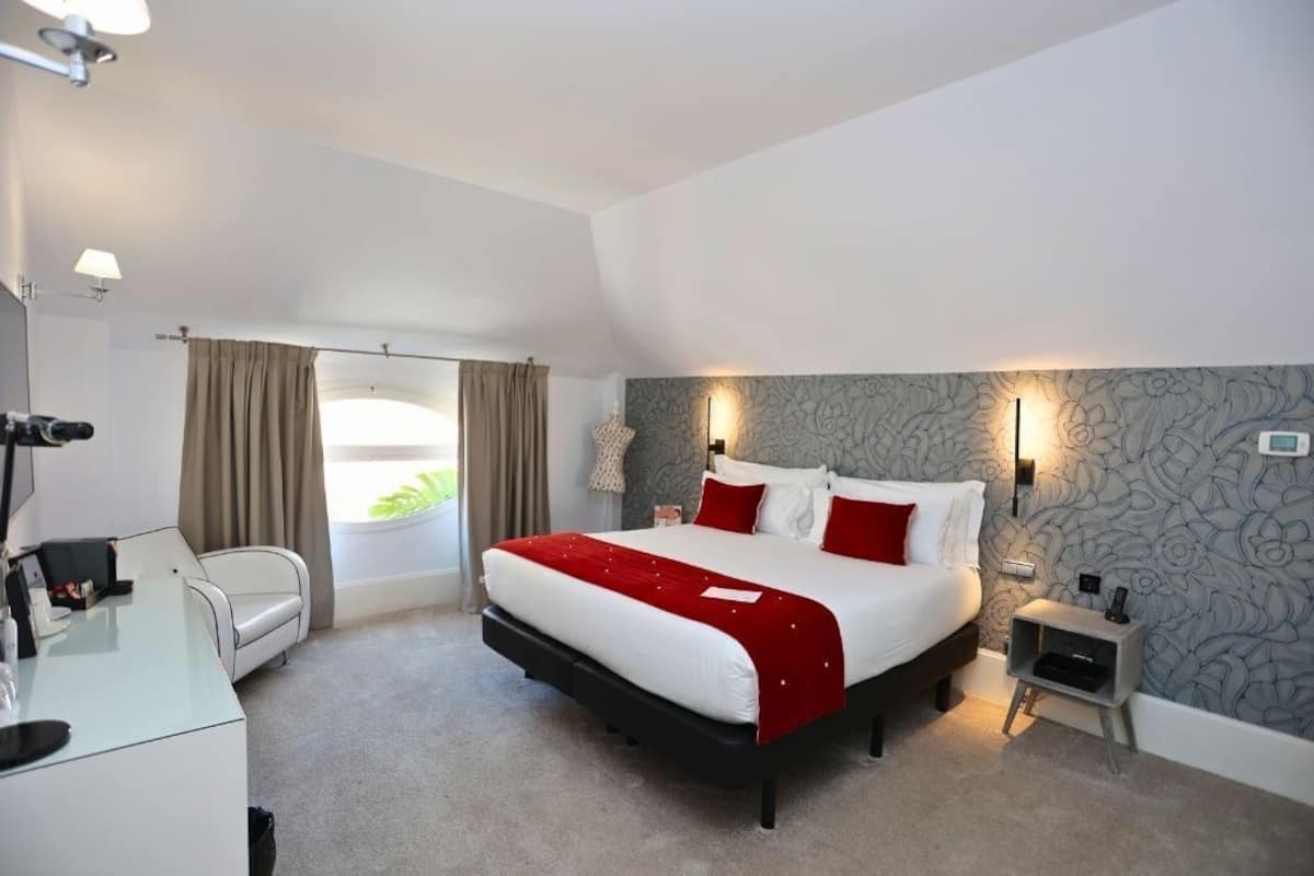 Una habitación de hotel moderna con una cama grande, un escritorio y una silla.