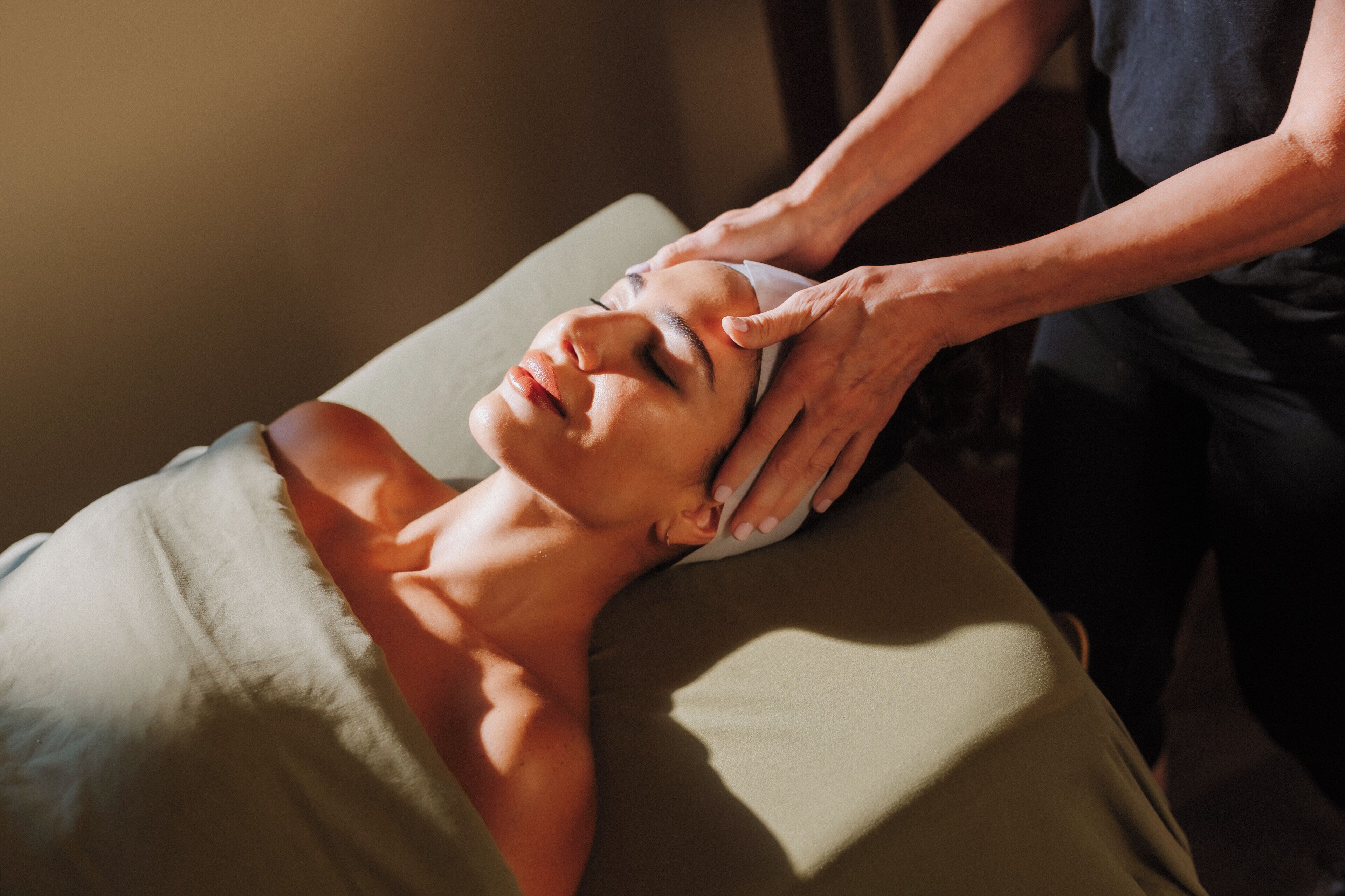 A person receiving a head massage on a massage table.