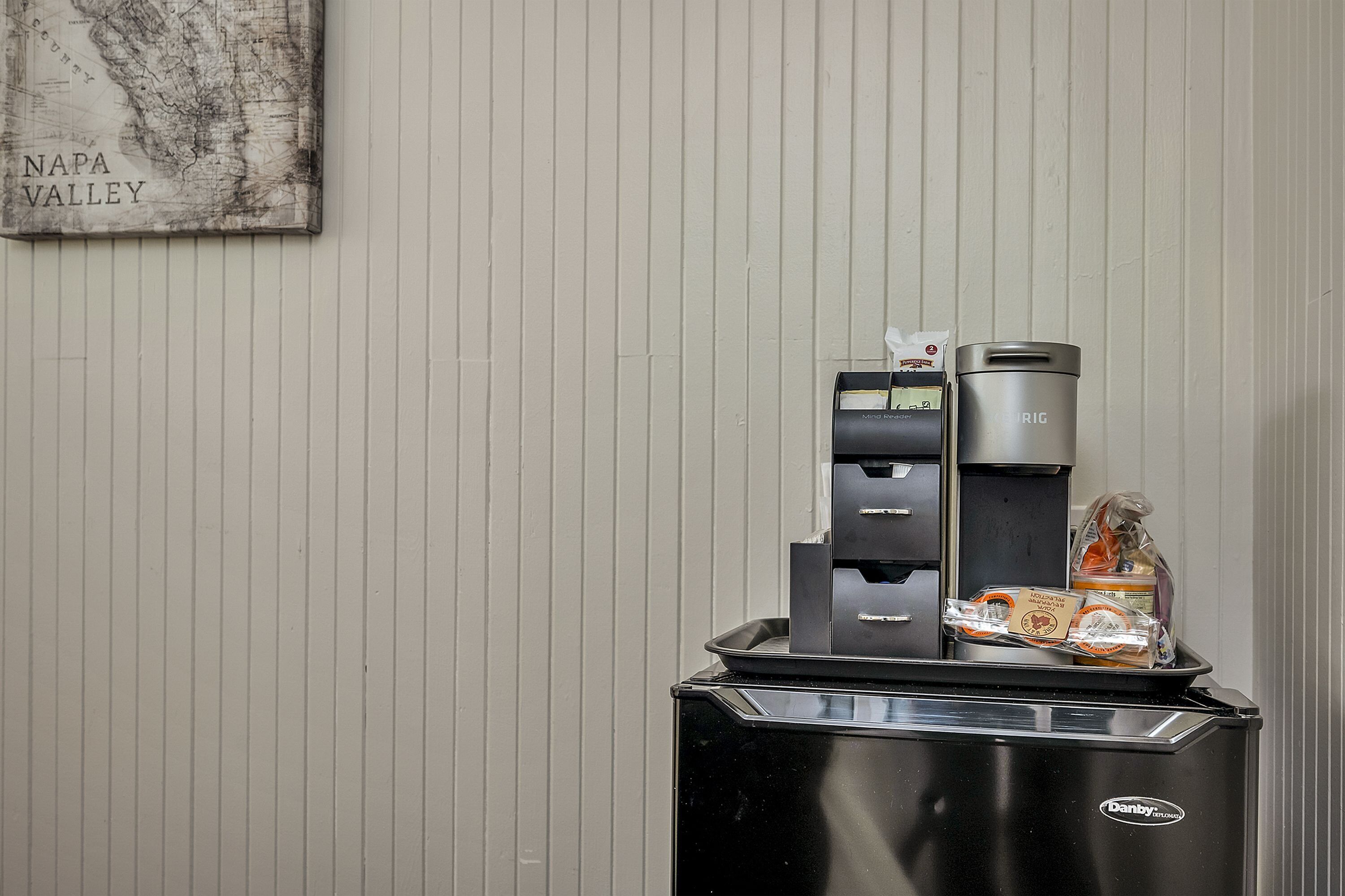 Eine Selbstbedienungs-Getränkestation mit Kaffeeautomaten, Wasserspender und Mülleimer.