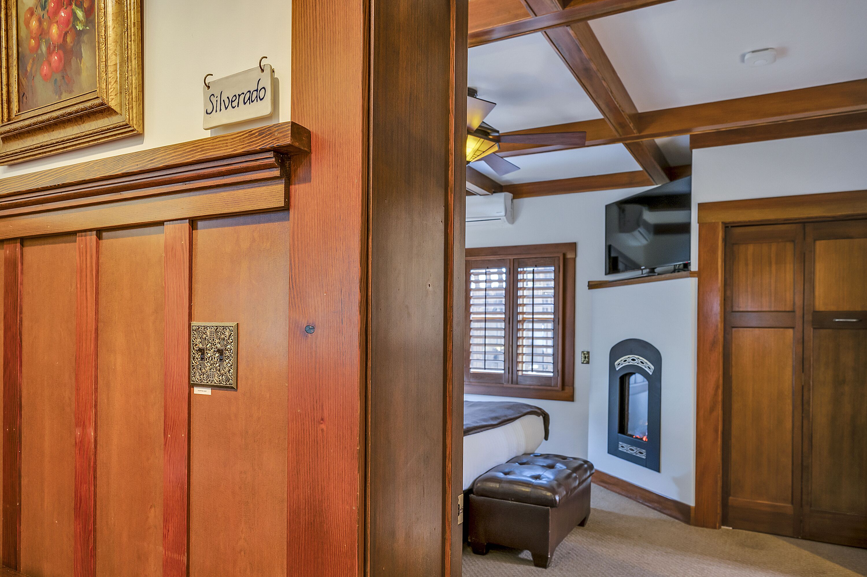 A wooden door with a nameplate, a fireplace, and a window with blinds.