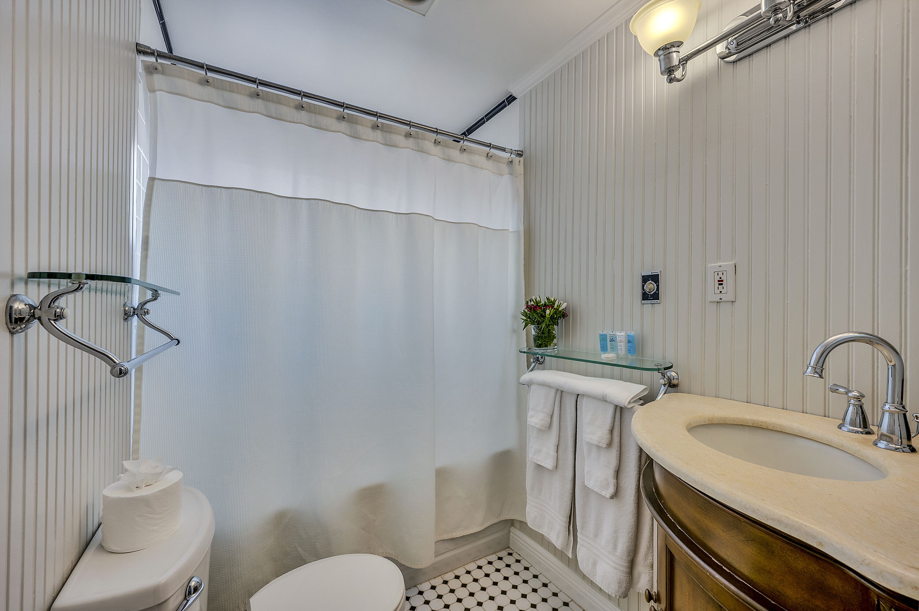 A bathroom with a toilet, sink, and shower curtain.