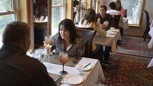 A restaurant with tables set for dining, a candle on each table, and a view of the outdoors through large windows. - Echo Canyon Spa Resort (Adults Only) (Sulphur)