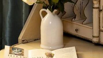 A table with a white pitcher, an open book, and a map.