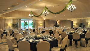 A banquet hall with round tables set for dining, chandeliers, and draped curtains. - Hotel Santiago de León (Villaquilambre)