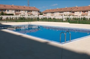 Una piscina al aire libre, tumbonas