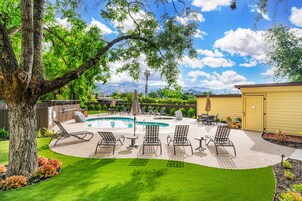 Una piscina al aire libre, sombrillas, sillones reclinables de piscina