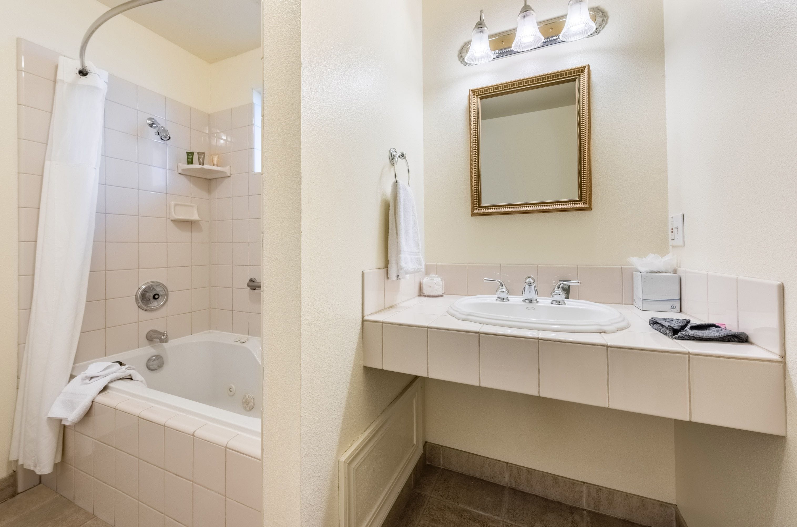 A bathroom with a bathtub, a sink, a mirror, and a shower curtain.