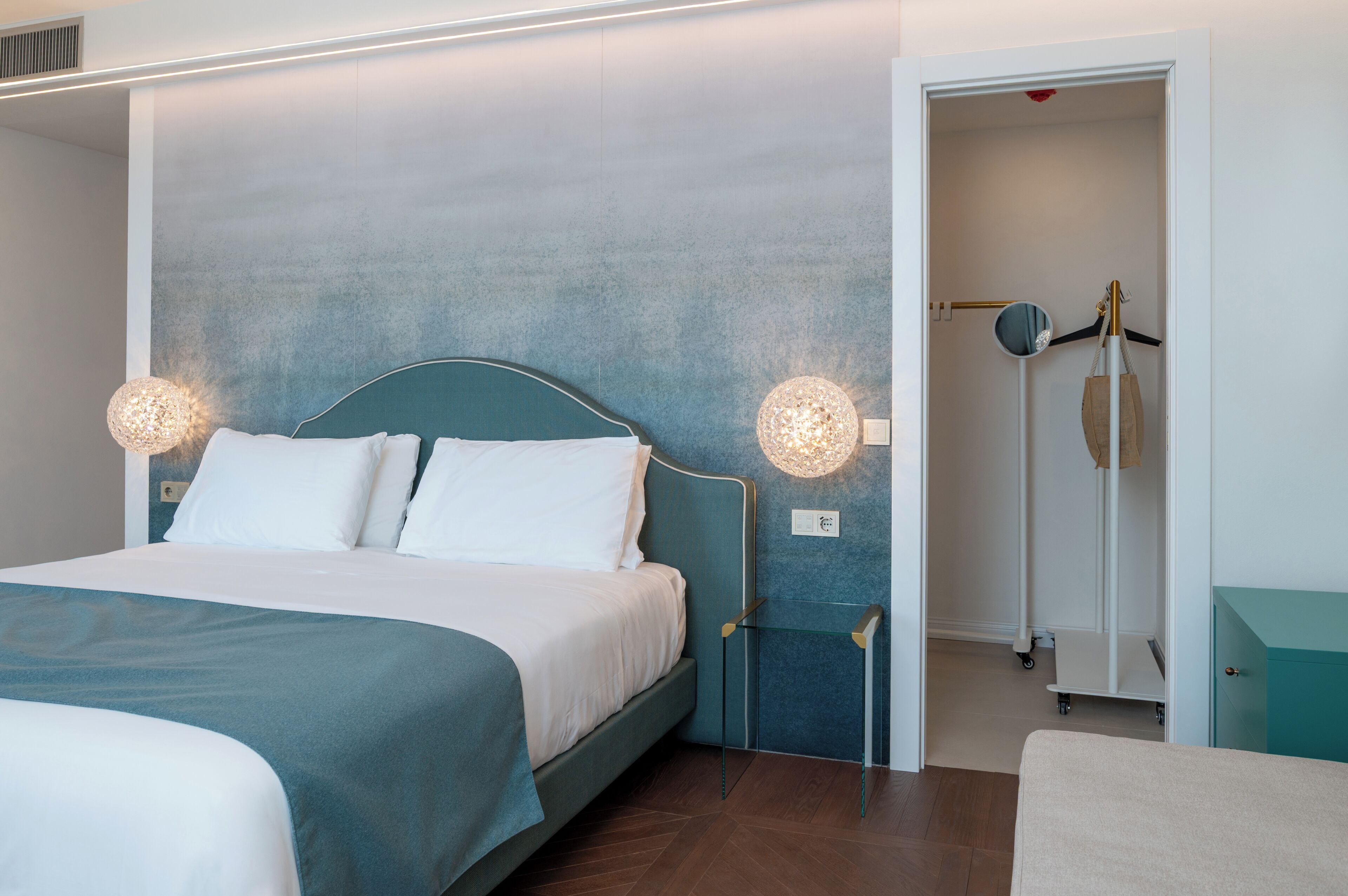 Un dormitorio moderno con cama, mesitas de noche y armario.