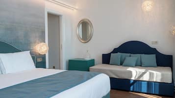 A bedroom with a bed, a sofa, a mirror, and two wall-mounted lights.
