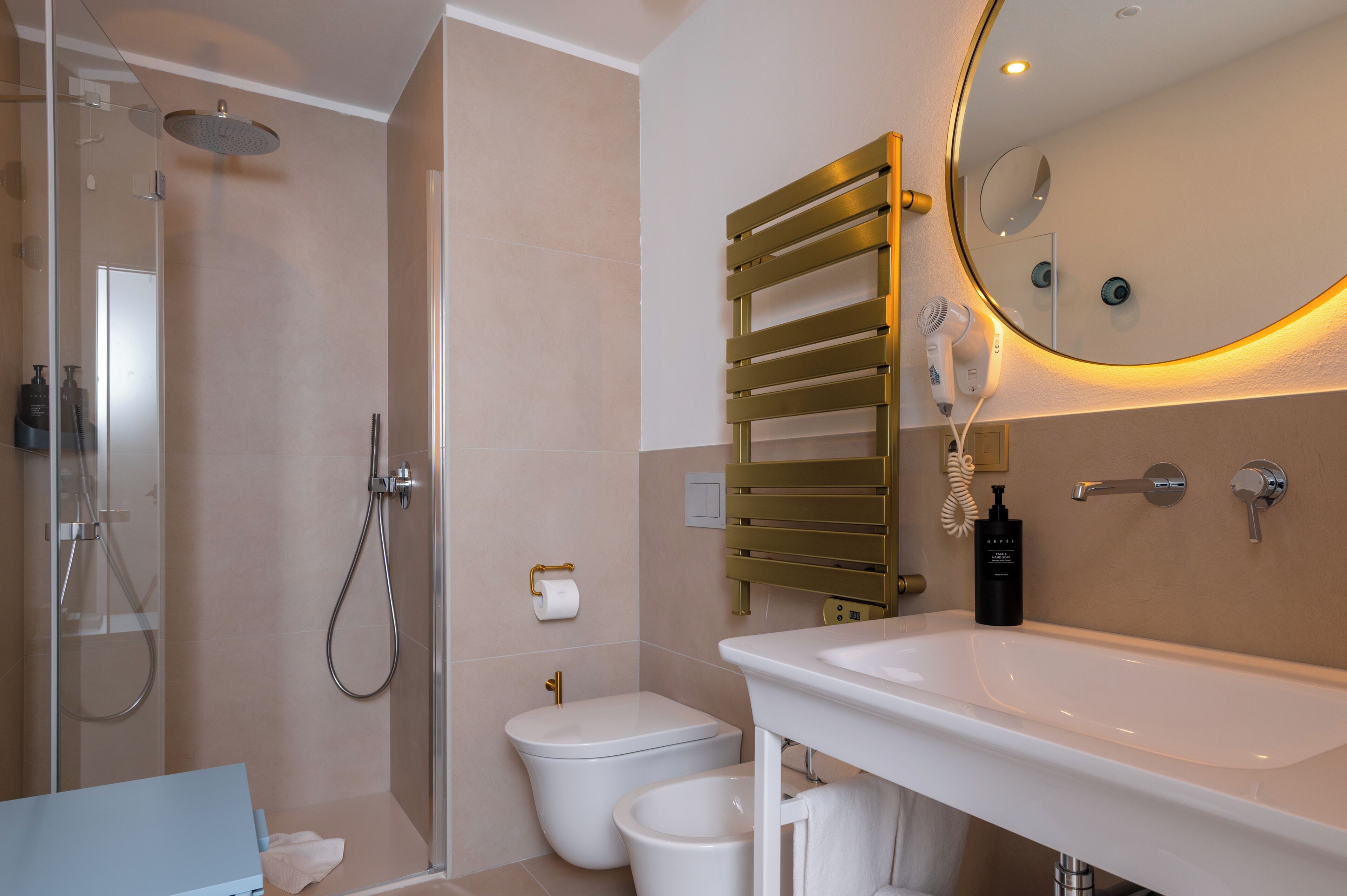 A modern bathroom with a shower, toilet, bidet, and sink.