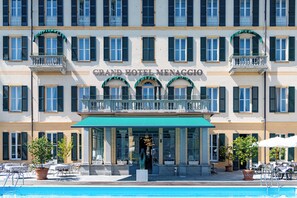 Un hotel con una entrada destacada, zona de estar al aire libre y piscina.