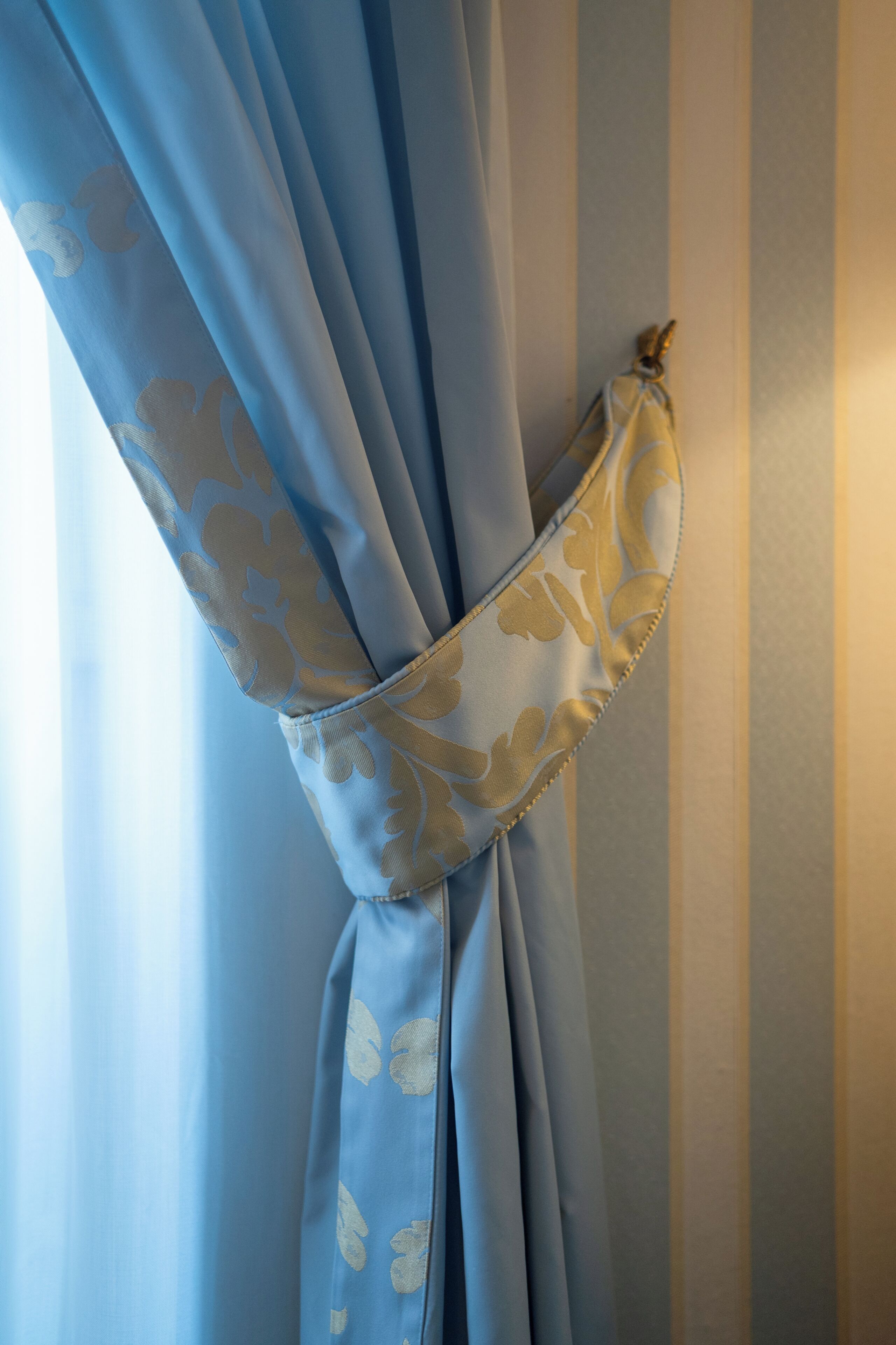 A curtain tied in a knot with a floral pattern.