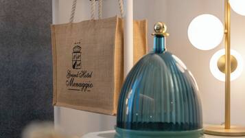 A room with a white dresser, a blue dome-shaped object on top, a hanging black hanger, a white bag with text, and a lamp with round lights.