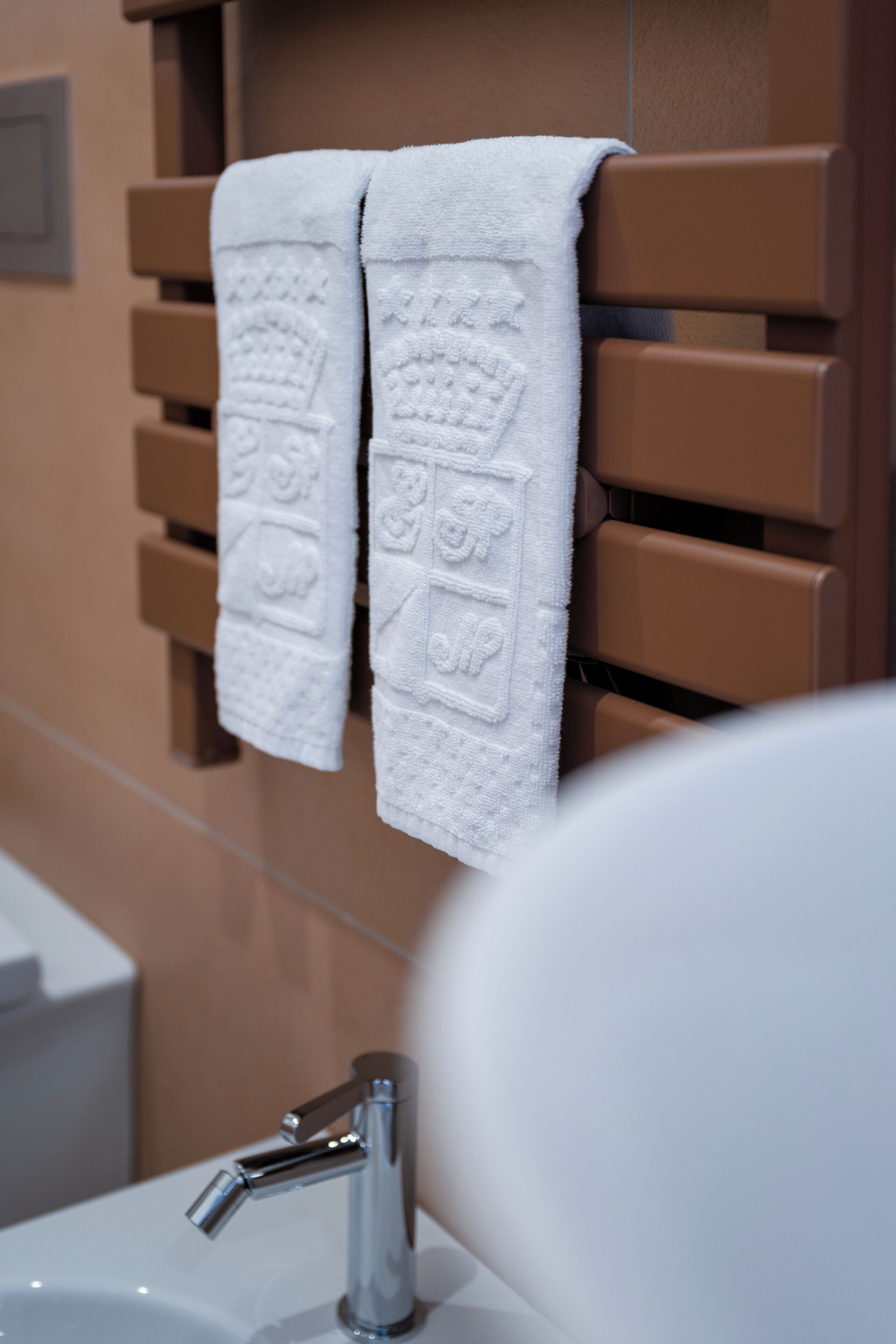 A bathroom with a towel rack holding two towels, a sink, and a mirror.