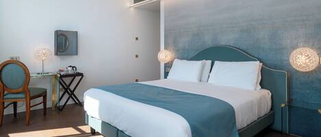 Une chambre à coucher moderne avec un lit, des lampes de chevet, un bureau et une chaise.