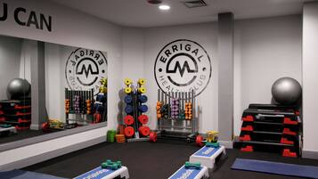 A gym with weightlifting equipment, mirrors, and a Reebok logo on the floor.