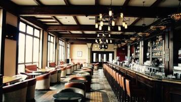A bar with multiple seating areas, including booths and tables, and a bar counter with various bottles and glasses.
