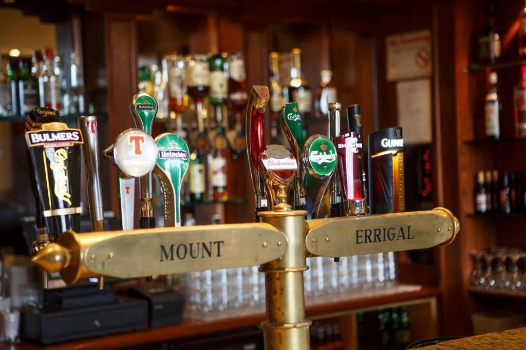 Una barra con múltiples grifos identificados con marcas de cerveza como Heineken, Guinness y Bulmers.