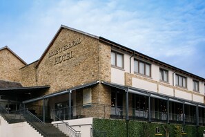A hotel with a stone facade and a covered outdoor area. - Mount Errigal Hotel Conference & Leisure Centre (Letterkenny)