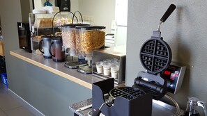 Enjoy a convenient breakfast at this self-service bar with a waffle maker, coffee machine, and selection of food items.