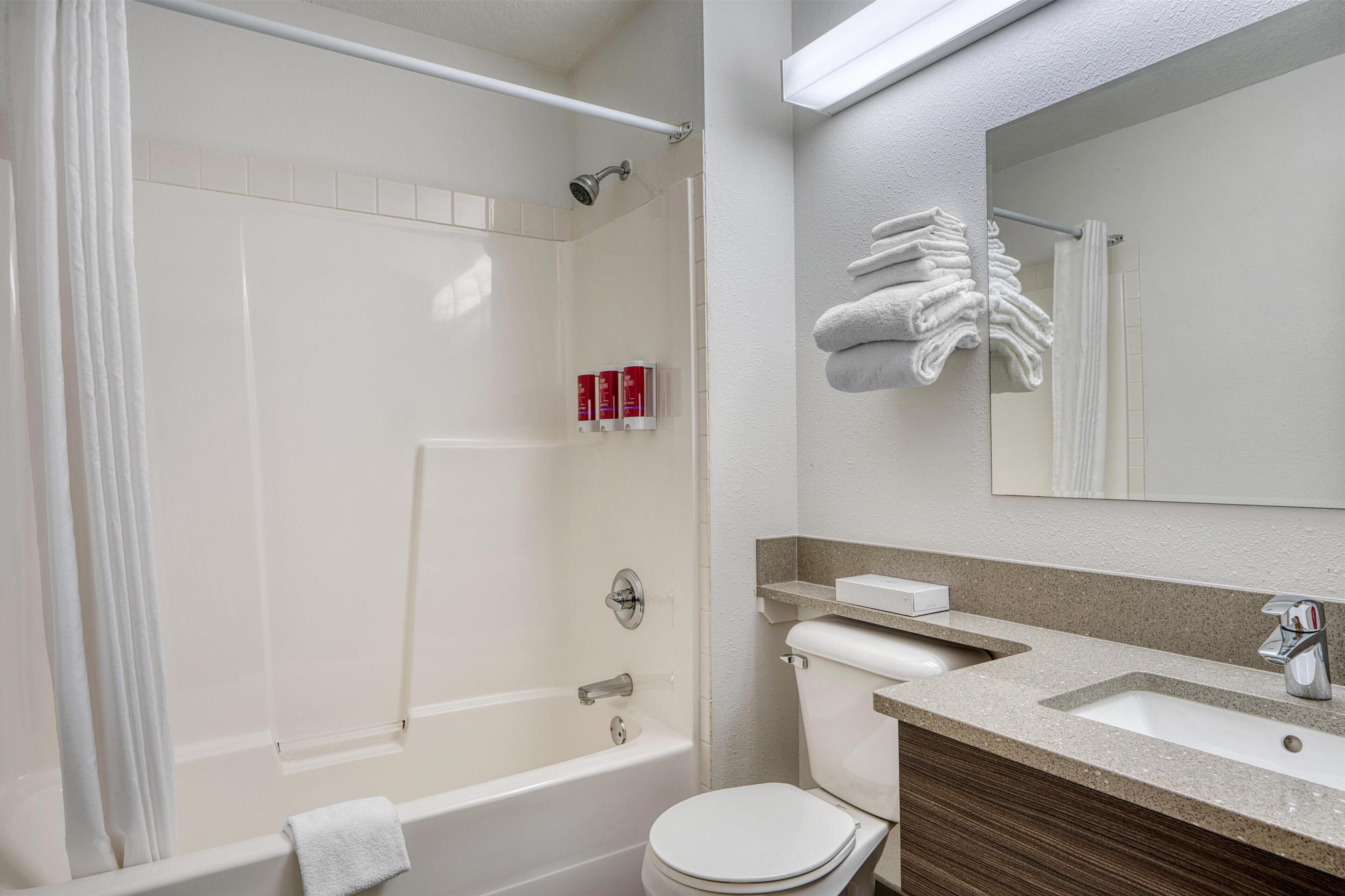 A modern bathroom with a bathtub, toilet, and sink.