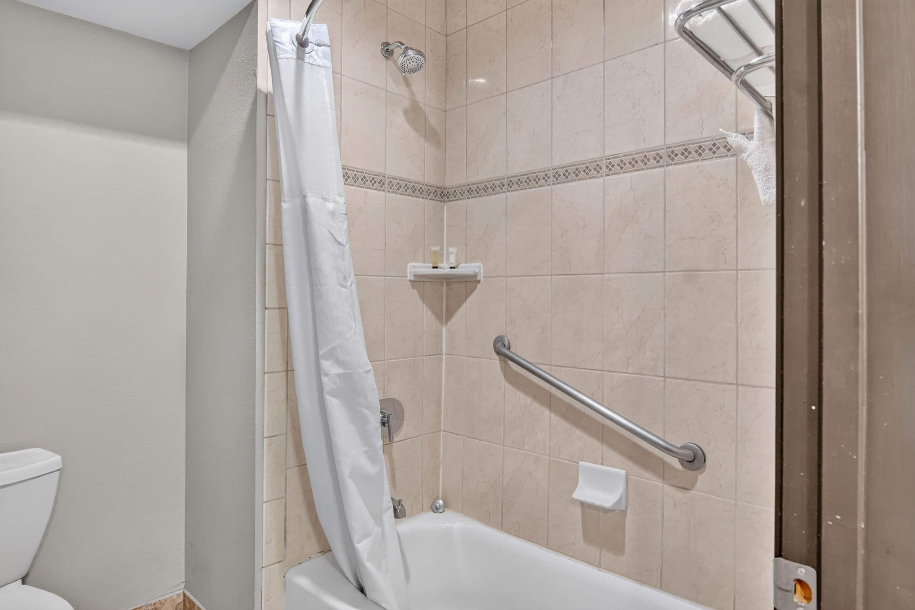 Une salle de bain avec une douche, des toilettes et une baignoire.