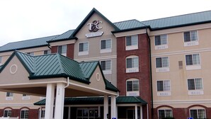 A Town & Country Inn and Suites building with a prominent entrance, multiple windows, and a green roof. - Town & Country Inn and Suites (Quincy)