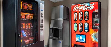 A vending machine with snacks and a Coca-Cola machine.