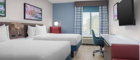 A hotel room with two beds, a desk, a chair, a flat-screen TV, and a window with curtains.