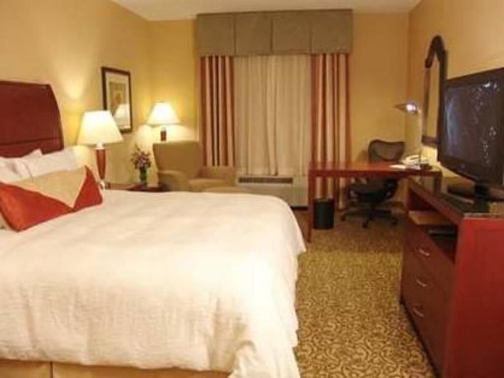 Escritorio, cortinas opacas, tabla de planchar con plancha