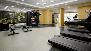 A modern gym with treadmills, weight machines, and exercise balls.
