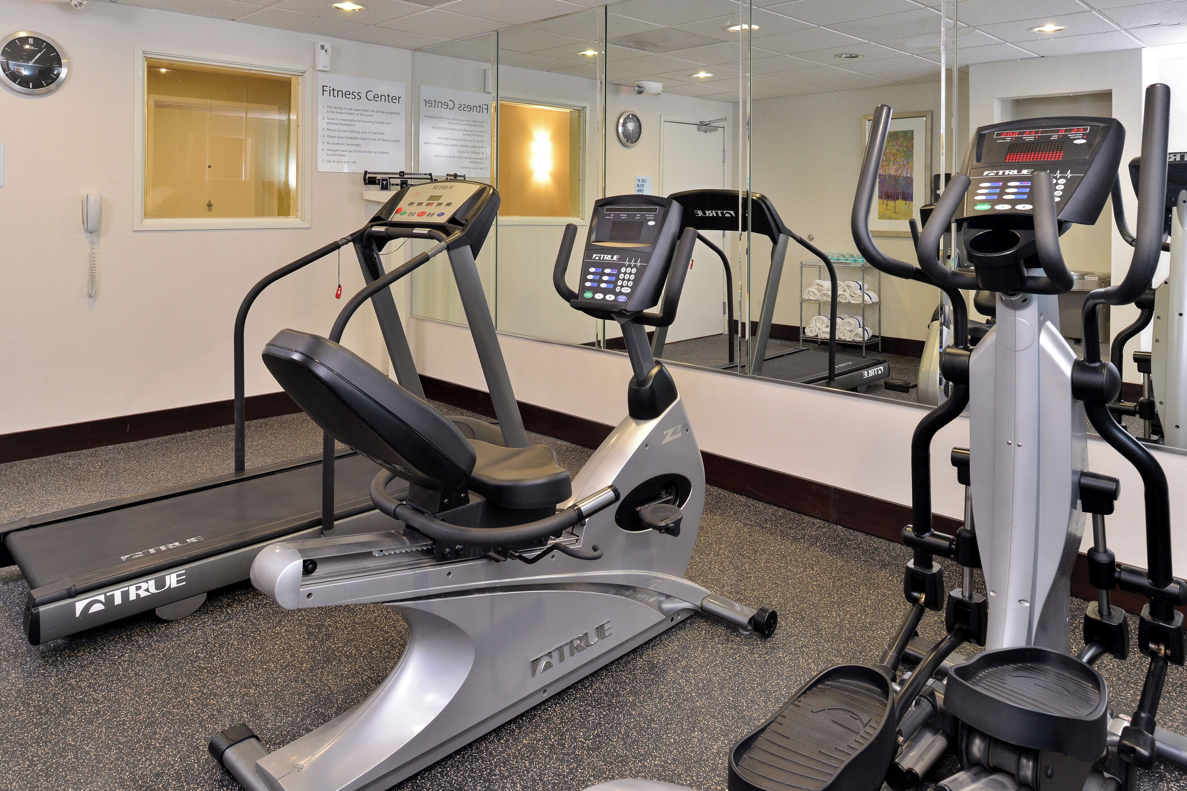 Ett träningscenter med löpband, en crosstrainer och en motionscykel.