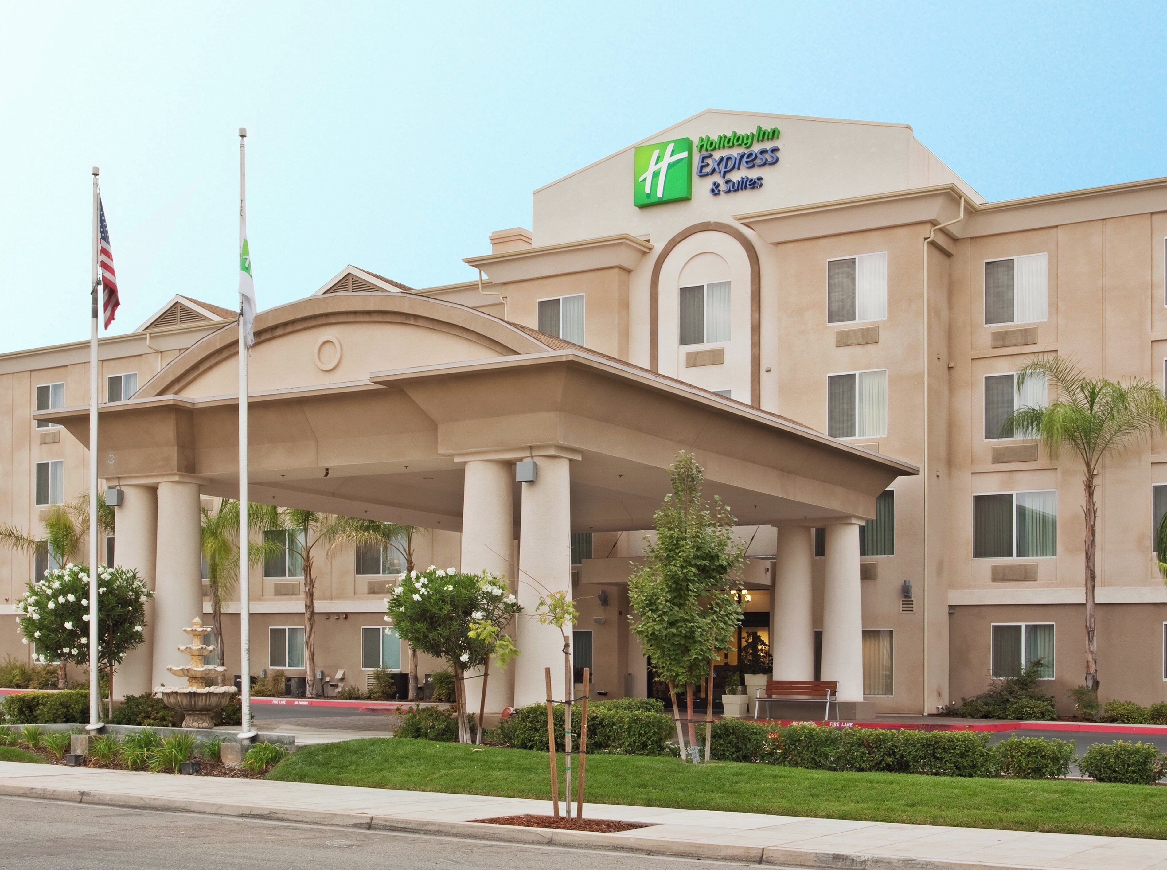 A hotel with a covered entrance, columns, and a sign for Holiday Inn Express & Suites.