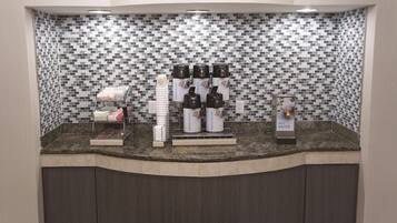 Una estación de café con varios dispensadores de café y un dispensador de agua caliente.