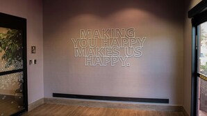 Eine Wand mit dem Schriftzug: 'MAKING YOU HAPPY MAKES US HAPPY'.