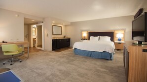 Ein Hotelzimmer mit Bett, Schreibtisch, Stuhl und Fernseher.