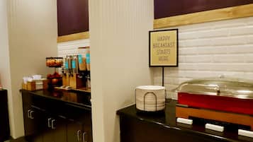 A breakfast buffet area with a sign that reads "HAPPY BREAKFAST STARTS HERE."