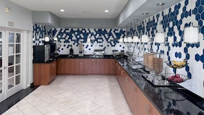 A modern kitchen with a central island, wooden cabinets, and a tiled backsplash. - La Quinta Inn & Suites by Wyndham Tulare (Tulare)