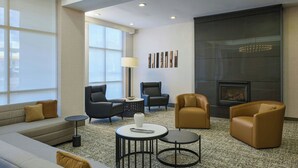 A modern living room with a sofa, armchairs, a fireplace, and a large window. - Residence Inn Tallahassee Universities at the Capitol (Tallahassee)