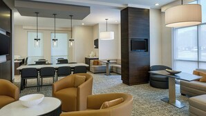 A modern hotel lobby with a dining area, seating arrangements, and a large window providing natural light. - Residence Inn Tallahassee Universities at the Capitol (Tallahassee)